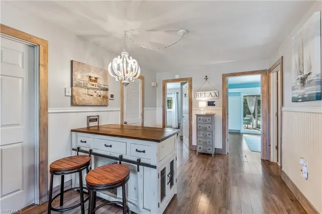 a dining room with furniture a chandelier and wooden floor