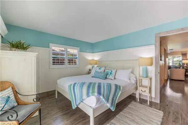 a bedroom with a bed wooden floor and lamp