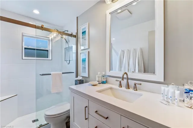 a bathroom with a sink toilet double vanity and shower