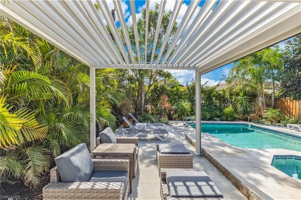 a view of backyard with swimming pool and outdoor seating