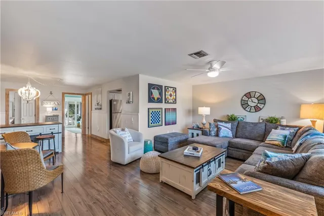a living room with furniture two night stand and a large window