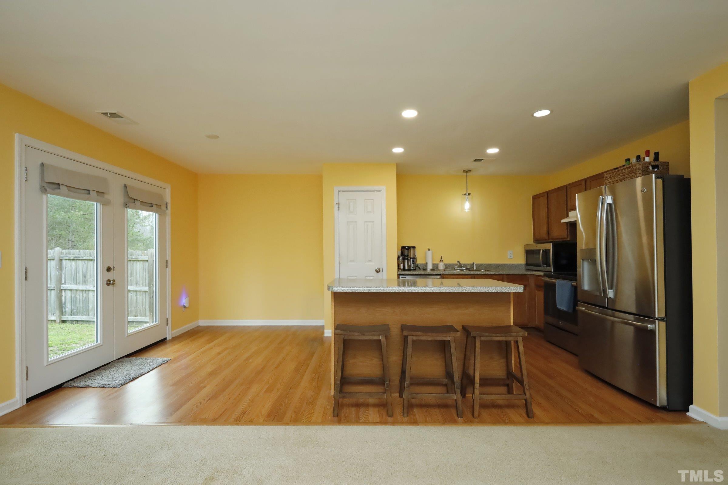 3608 Marshlane Way Raleigh, NC 27610 - Photo 11 of 43 a kitchen with a table and refrigerator in it