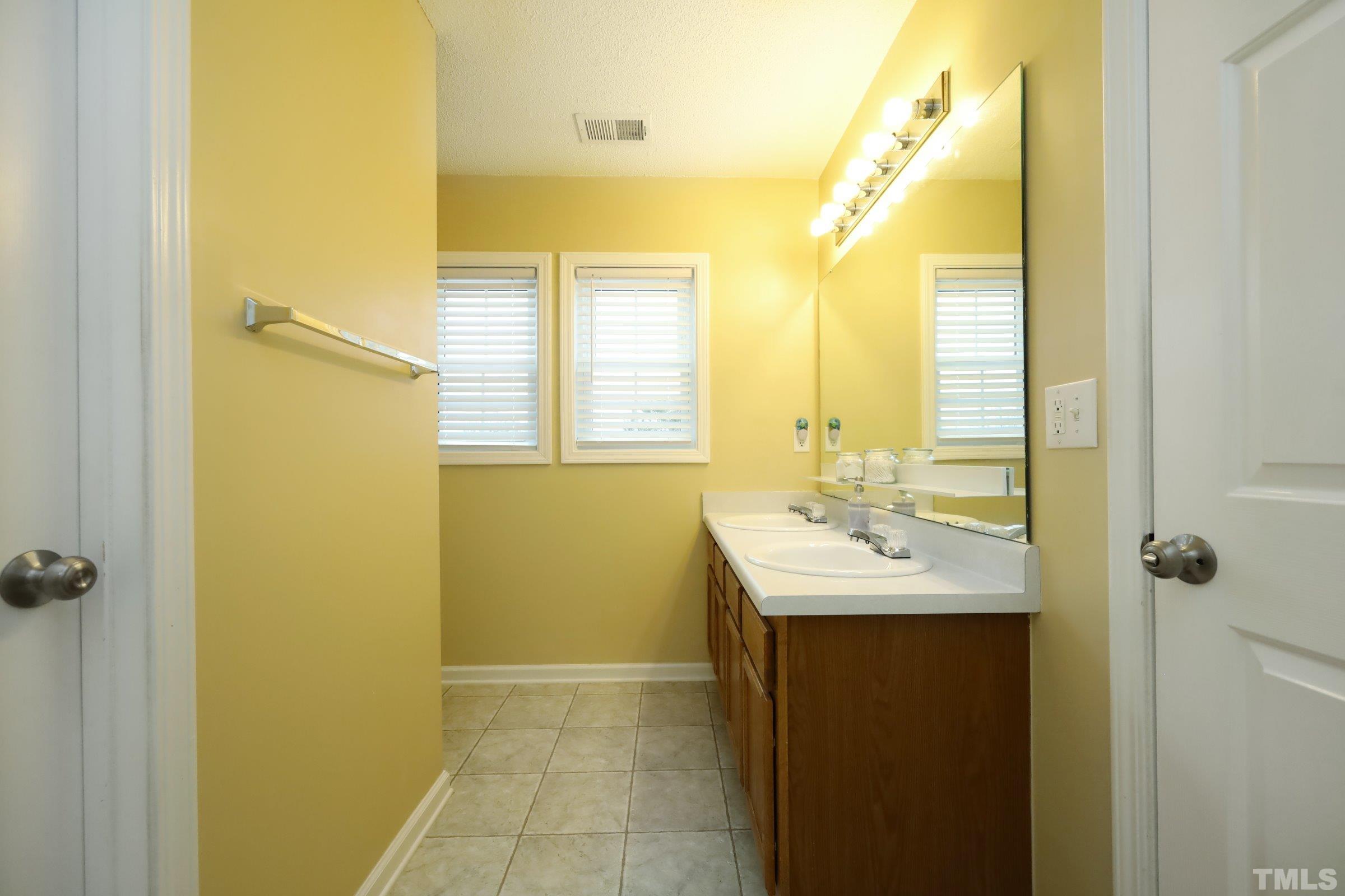 3608 Marshlane Way Raleigh, NC 27610 - Photo 26 of 43 a bathroom with a sink a mirror and a shower