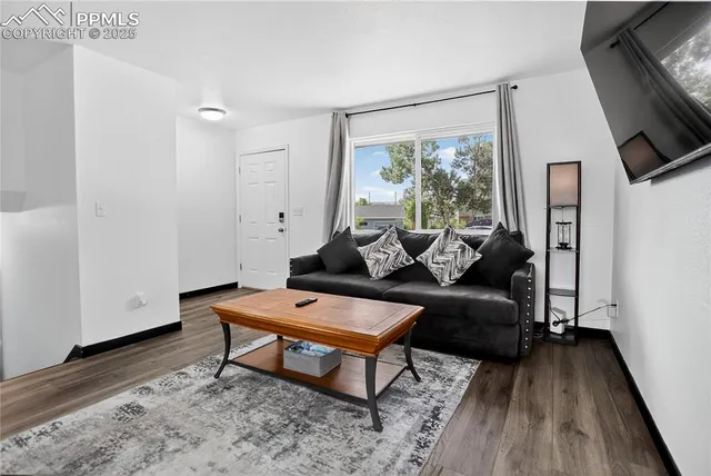a living room with furniture and a wooden floor