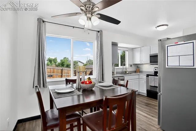 a kitchen with a table chairs and white cabinets