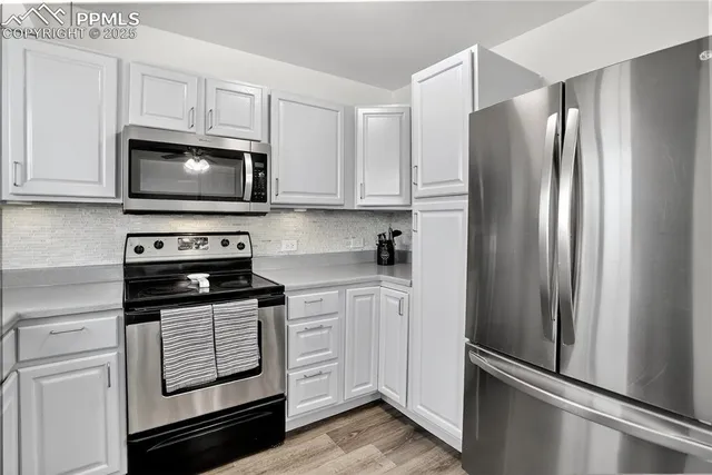 a kitchen with cabinets stainless steel appliances and a window