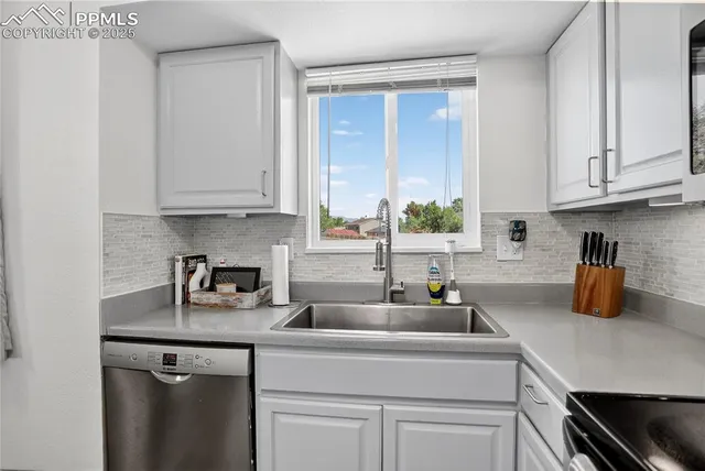 a kitchen with appliances a sink and cabinets