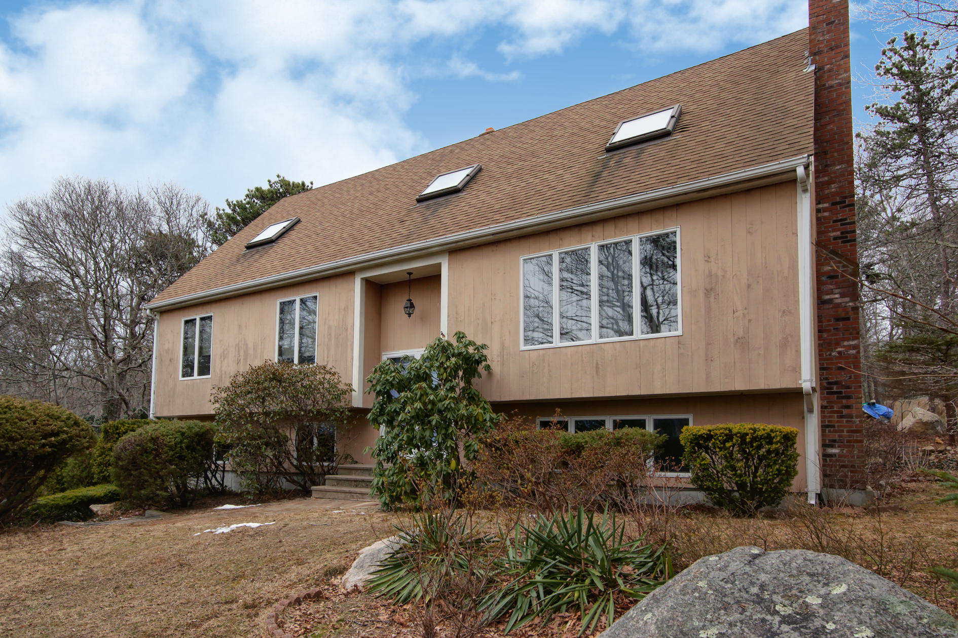 a front view of house with yard and trees in the background
