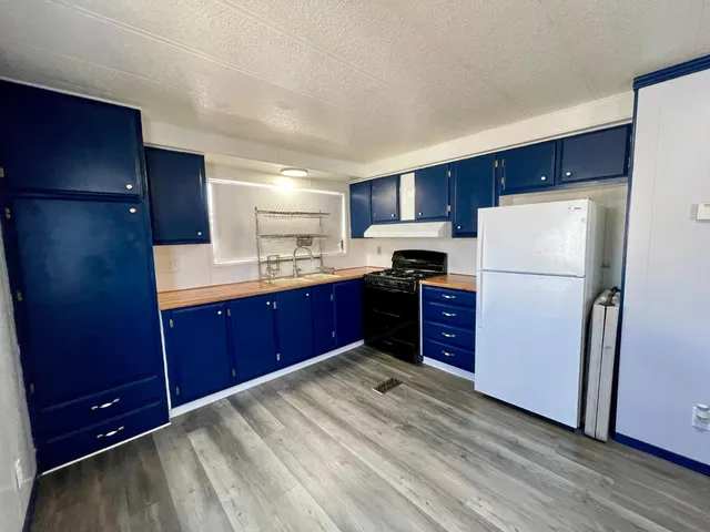 a kitchen with stainless steel appliances granite countertop a refrigerator a sink and a stove