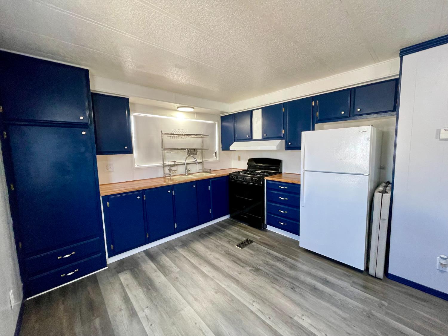 3998 Castro Valley Boulevard, Unit 34 Castro Valley, CA 94546 - Photo 3 of 17 a kitchen with stainless steel appliances granite countertop a refrigerator a sink and a stove