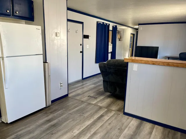 a view of kitchen with stainless steel appliances wooden floor and a refrigerator