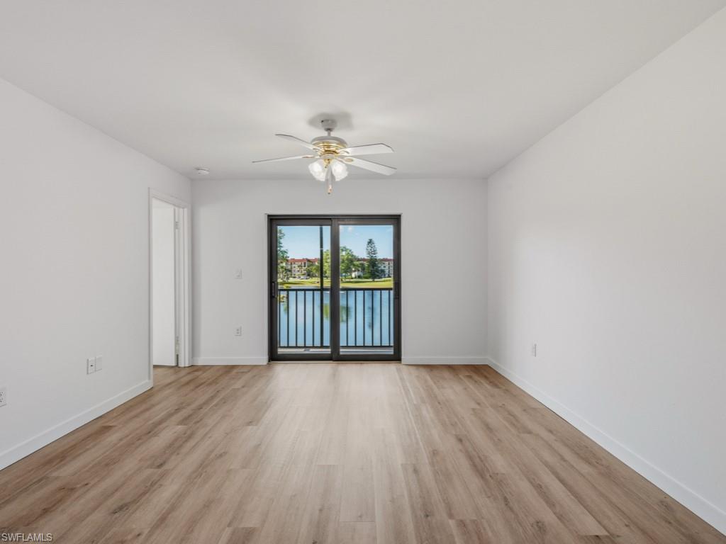 4245 27th Court Southwest, Unit 201 Naples, FL 34116 - Photo 11 of 14 a view of an empty room with a window and wooden floor