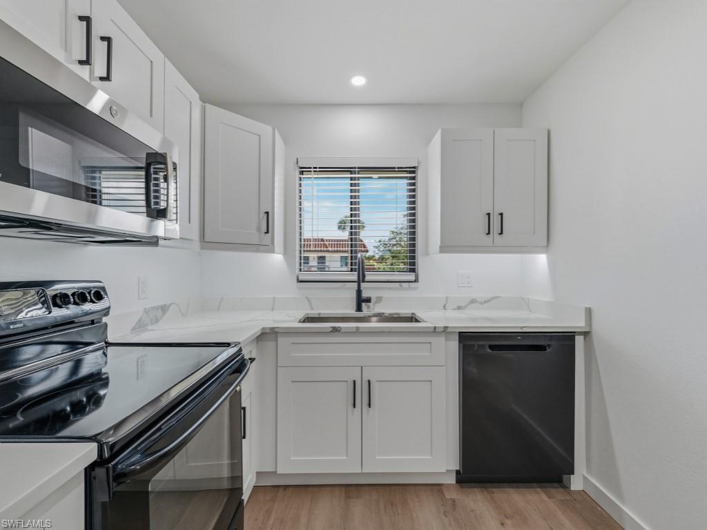 4245 27th Court Southwest, Unit 201 Naples, FL 34116 - Photo 4 of 14 a kitchen with a sink stove and cabinets