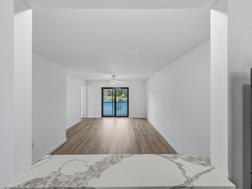 4245 27th Court Southwest, Unit 201 Naples, FL 34116 - Photo 5 of 14 view of wooden floor and windows in a room