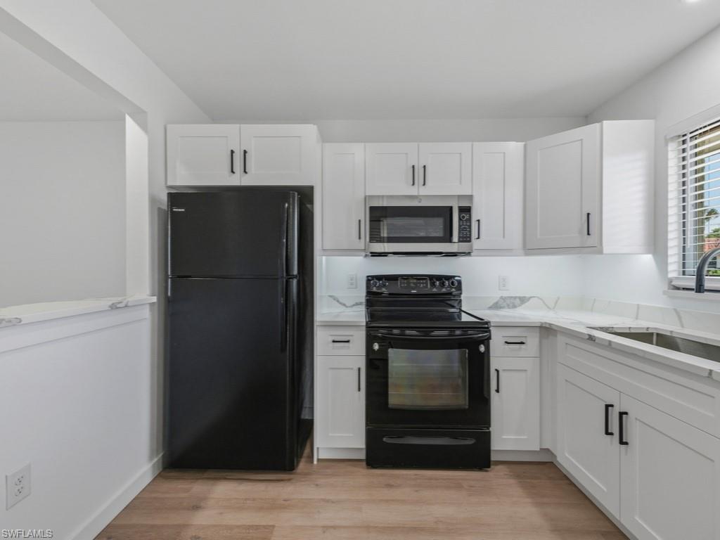 4245 27th Court Southwest, Unit 201 Naples, FL 34116 - Photo 6 of 14 a kitchen with a refrigerator stove and sink