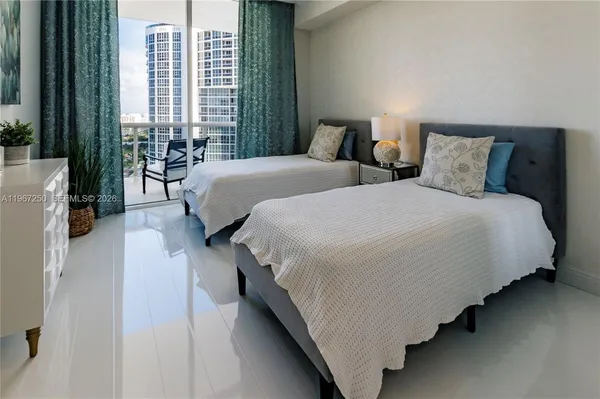 a bedroom with two beds and large window