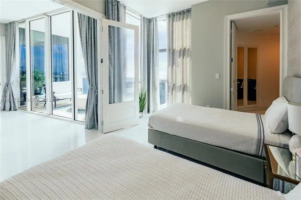 a large bedroom with a large window and glass door