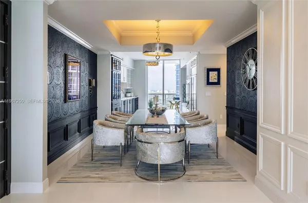 a living room with stainless steel appliances kitchen island granite countertop furniture and a chandelier