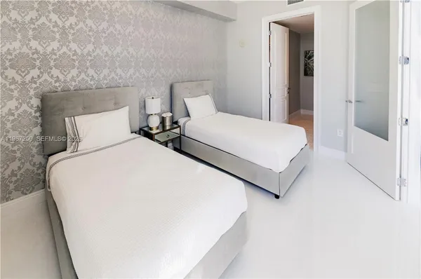 a bedroom with a bed and a large mirror
