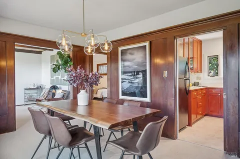 a view of a dining room with furniture and a chandelier