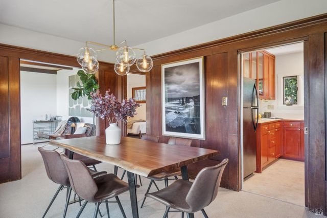 a view of a dining room with furniture and a chandelier