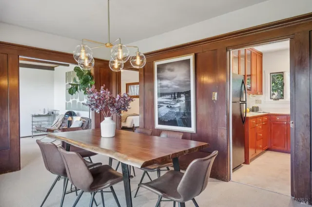 a view of a dining room with furniture and a chandelier