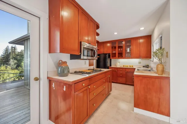 a kitchen with stainless steel appliances granite countertop a stove a sink and a refrigerator