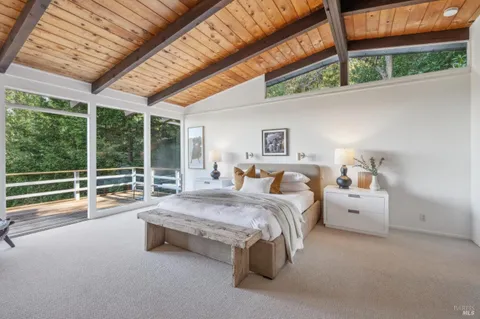 a spacious bedroom with a bed and large windows