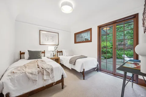 a spacious bedroom with two beds and a large window