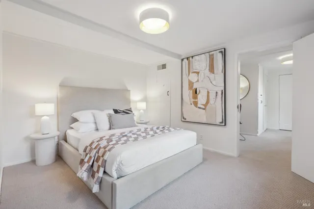 a bedroom with a large bed and paintings on the wall