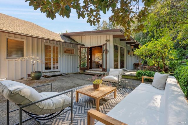 a view of a house with backyard and sitting area
