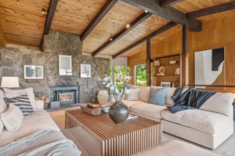 a living room with furniture a fireplace and a table