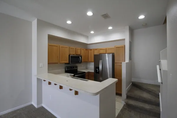 a kitchen with stainless steel appliances a refrigerator sink and microwave