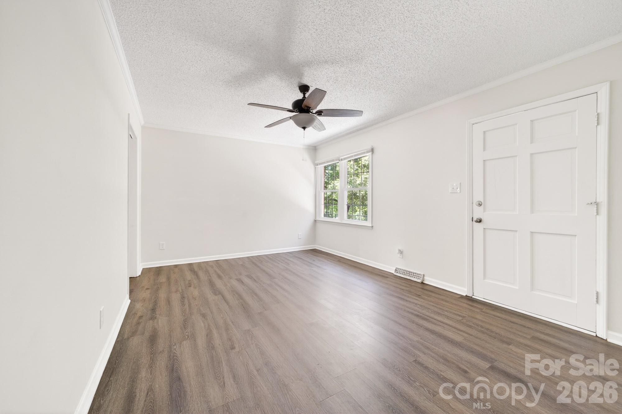 204 Harrelson Road Cherryville, NC 28021 - Photo 13 of 34 an empty room with wooden floor chandelier fan and windows