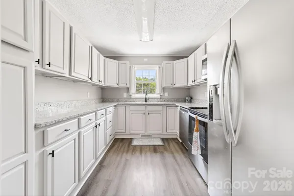 a kitchen with white cabinets sink and stainless steel appliances