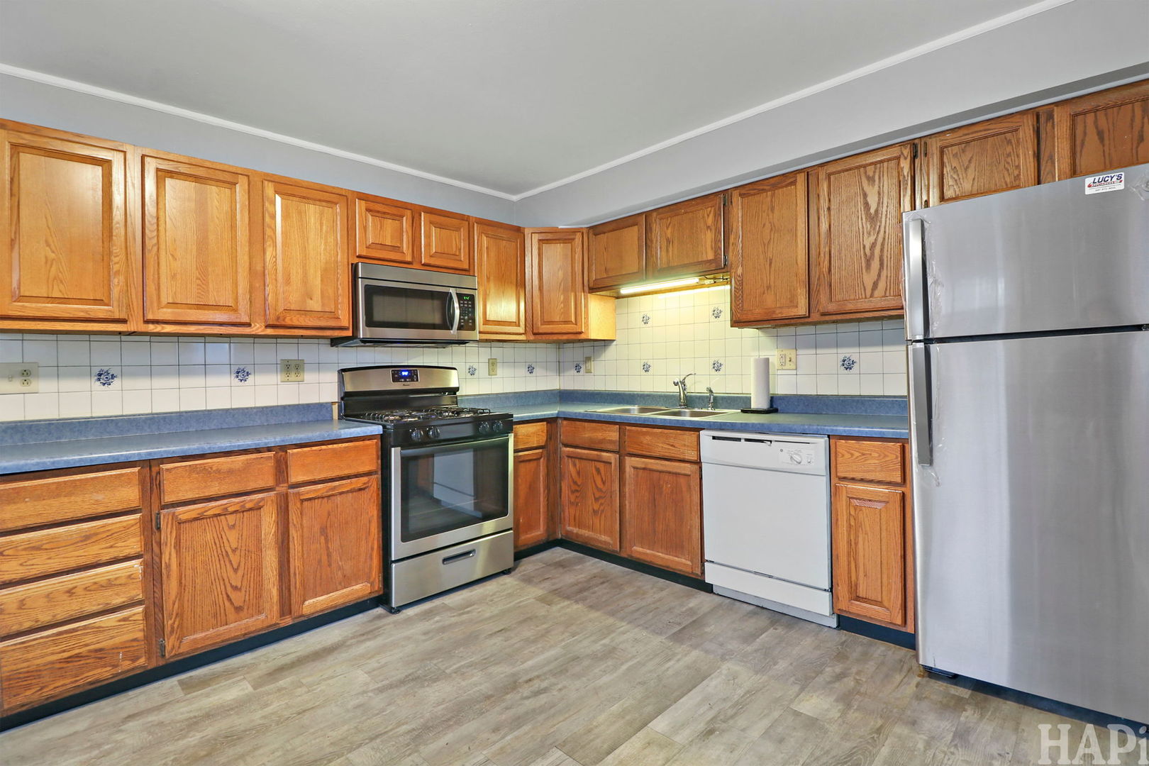 2217 20th Street Zion, IL 60099 - Photo 8 of 24 a kitchen with granite countertop a refrigerator stove top oven a sink and dishwasher with wooden floor