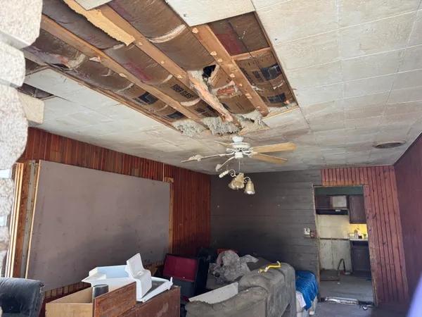 a bedroom with a bed and a chandelier fan