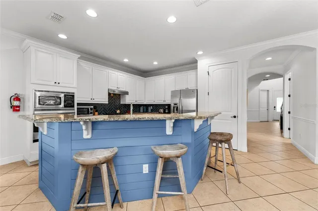 a view of a white house with a yard table and chairs