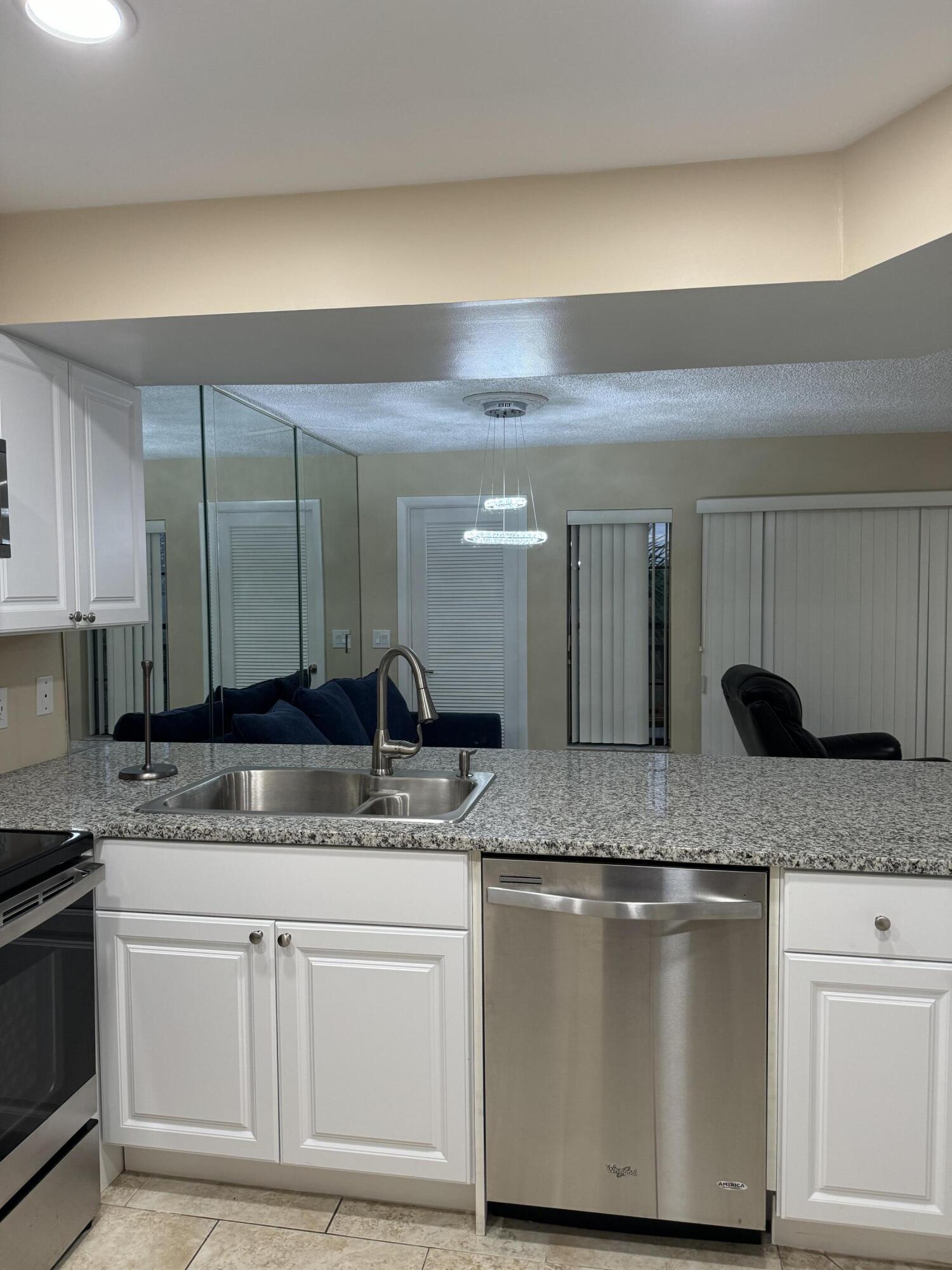 1605 Highway 1, Unit V6306 Jupiter, FL 33477 - Photo 12 of 34 a bathroom with a granite countertop sink a mirror and vanity