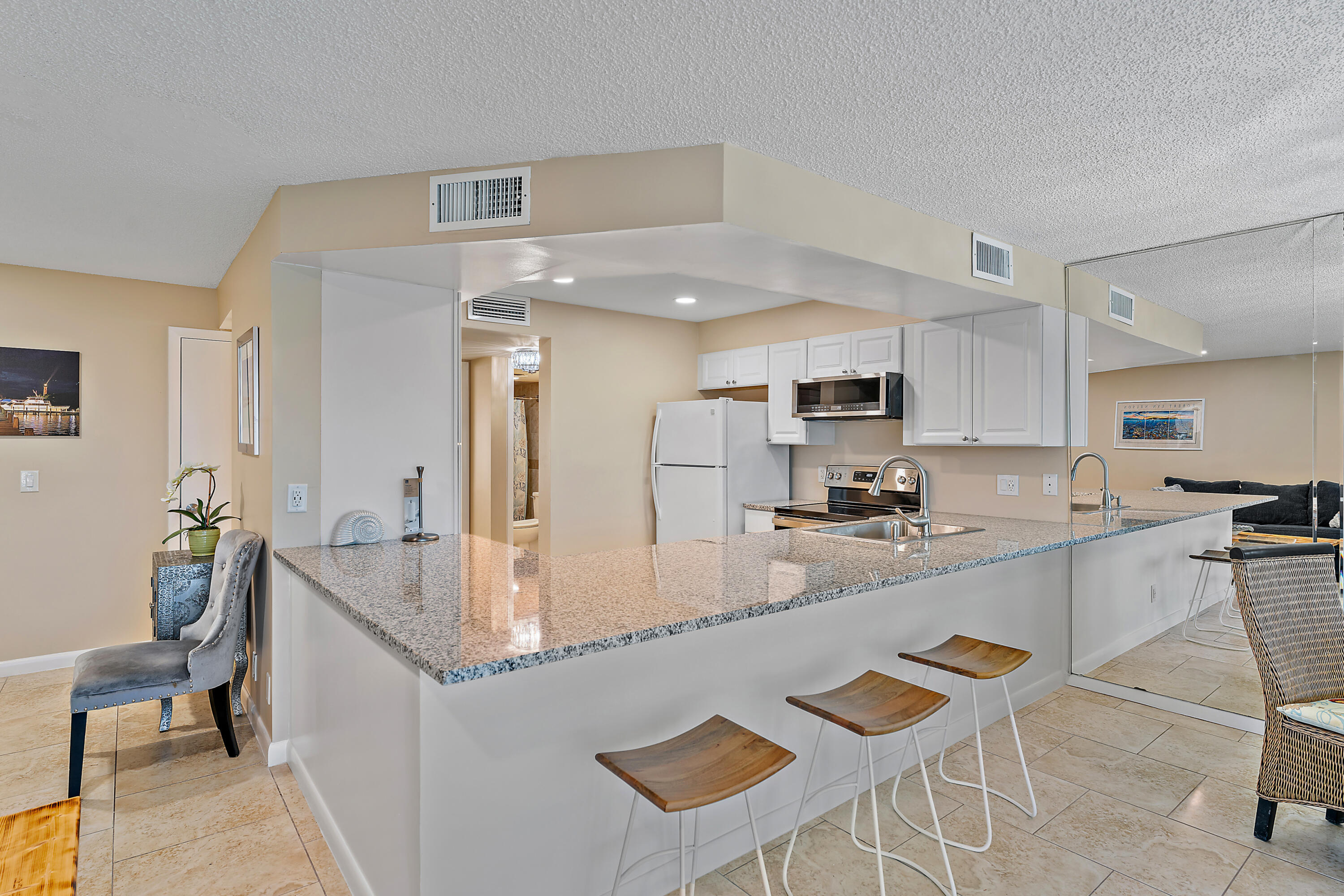 1605 Highway 1, Unit V6306 Jupiter, FL 33477 - Photo 16 of 34 a kitchen with kitchen island granite countertop a sink and counter space