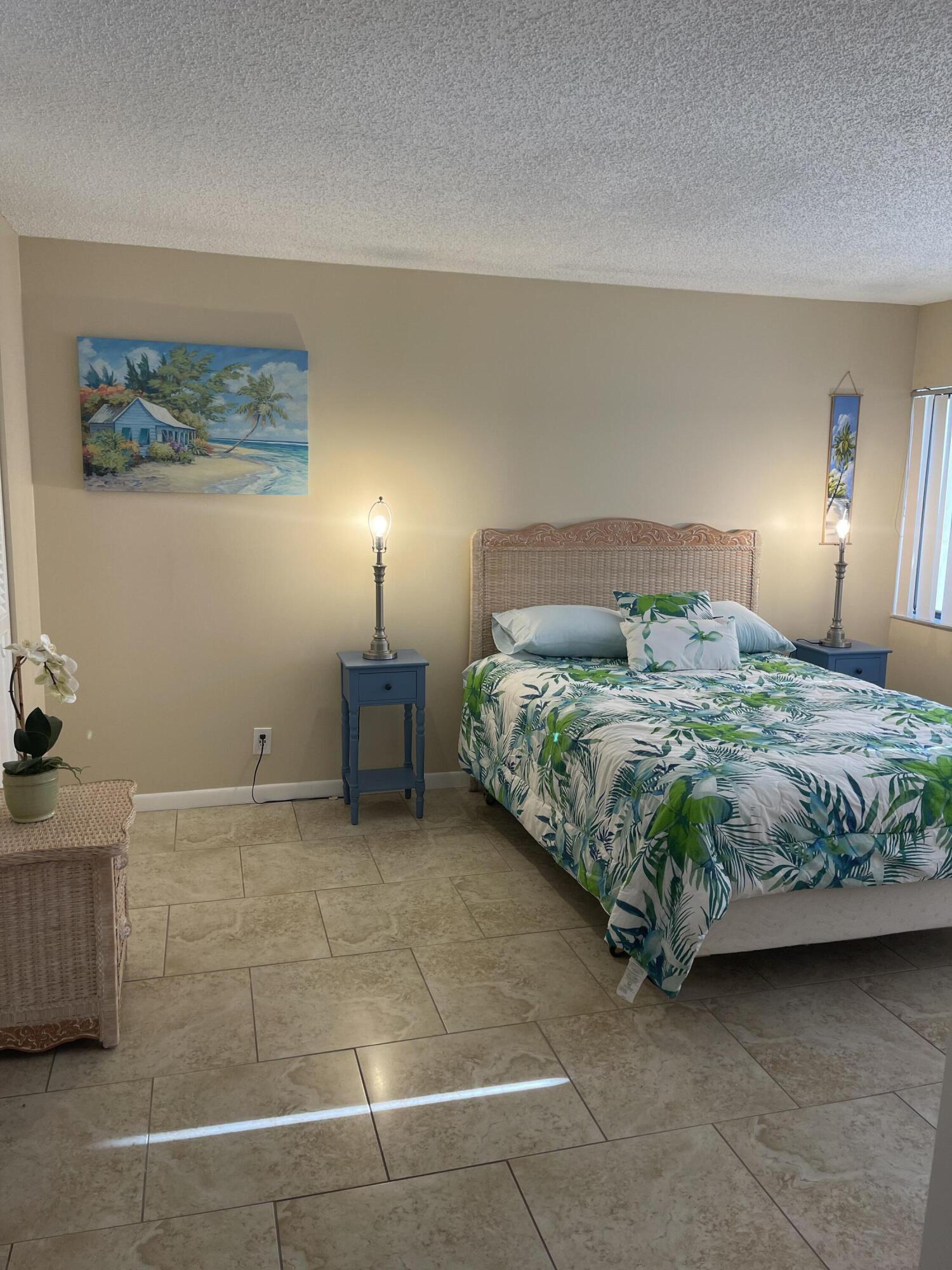 1605 Highway 1, Unit V6306 Jupiter, FL 33477 - Photo 21 of 34 a bedroom with a bed and a lamp on the dresser