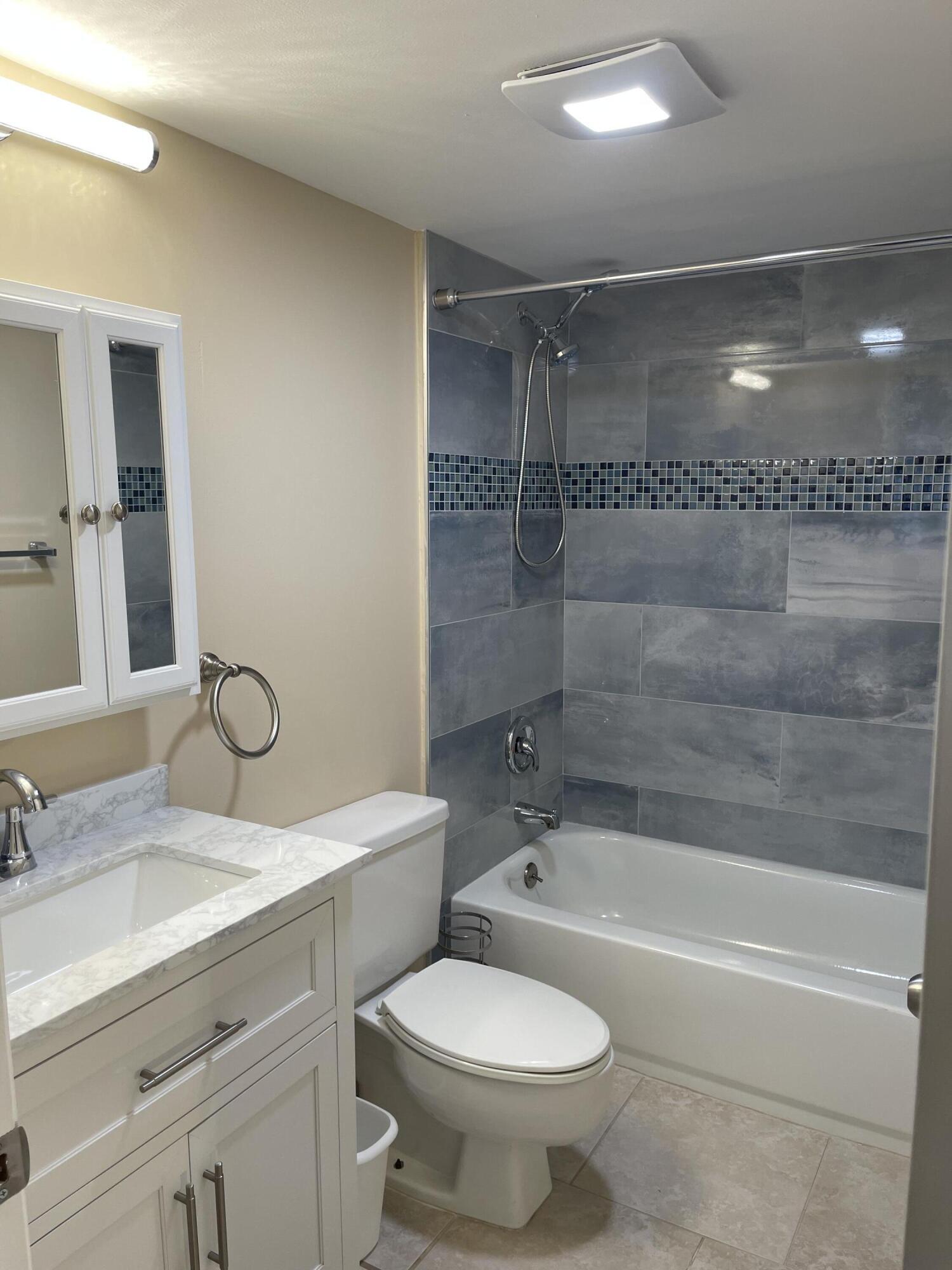 1605 Highway 1, Unit V6306 Jupiter, FL 33477 - Photo 29 of 34 a bathroom with a granite countertop sink toilet and shower