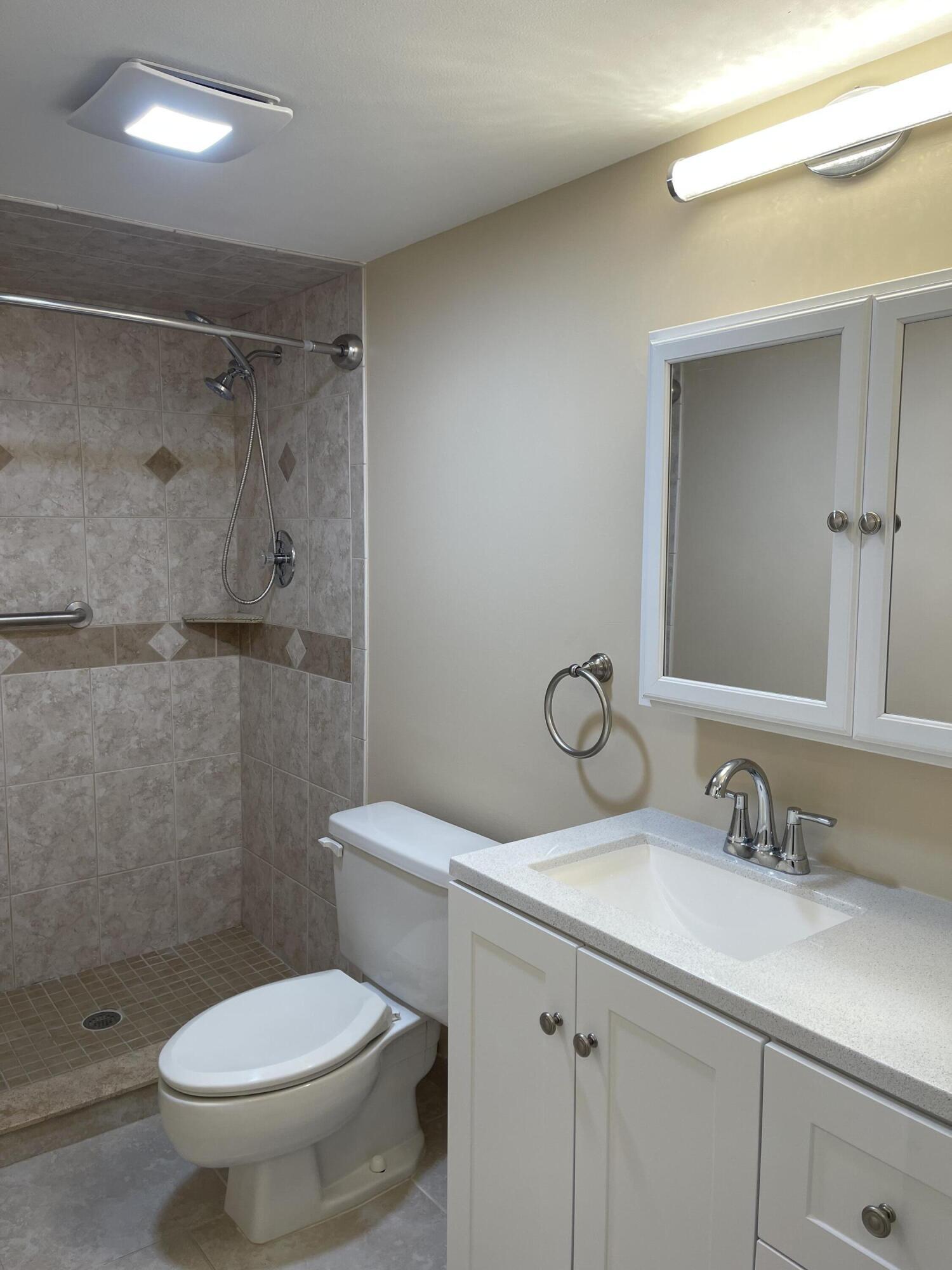 1605 Highway 1, Unit V6306 Jupiter, FL 33477 - Photo 30 of 34 a bathroom with a granite countertop toilet sink and a mirror