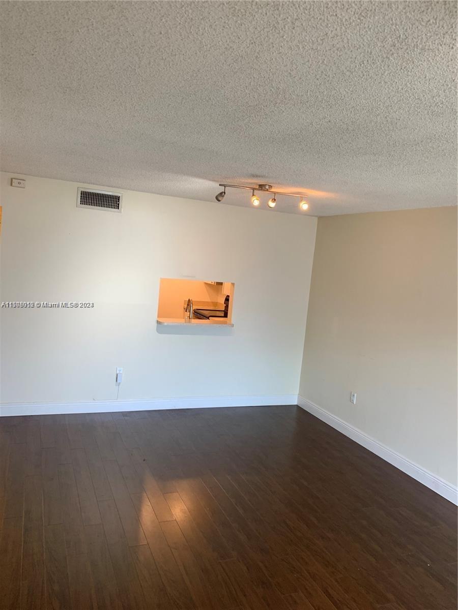 711 North Pine Island Road, Unit 111 Plantation, FL 33324 - Photo 4 of 14 an empty room with a wooden floor