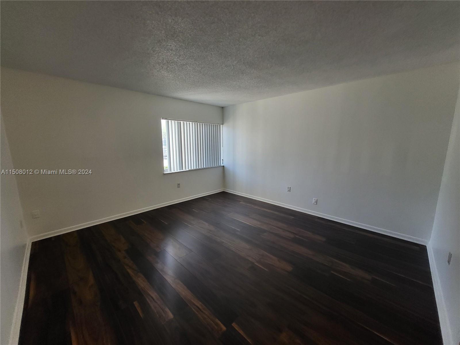 711 North Pine Island Road, Unit 111 Plantation, FL 33324 - Photo 6 of 14 an empty room with wooden floor and windows