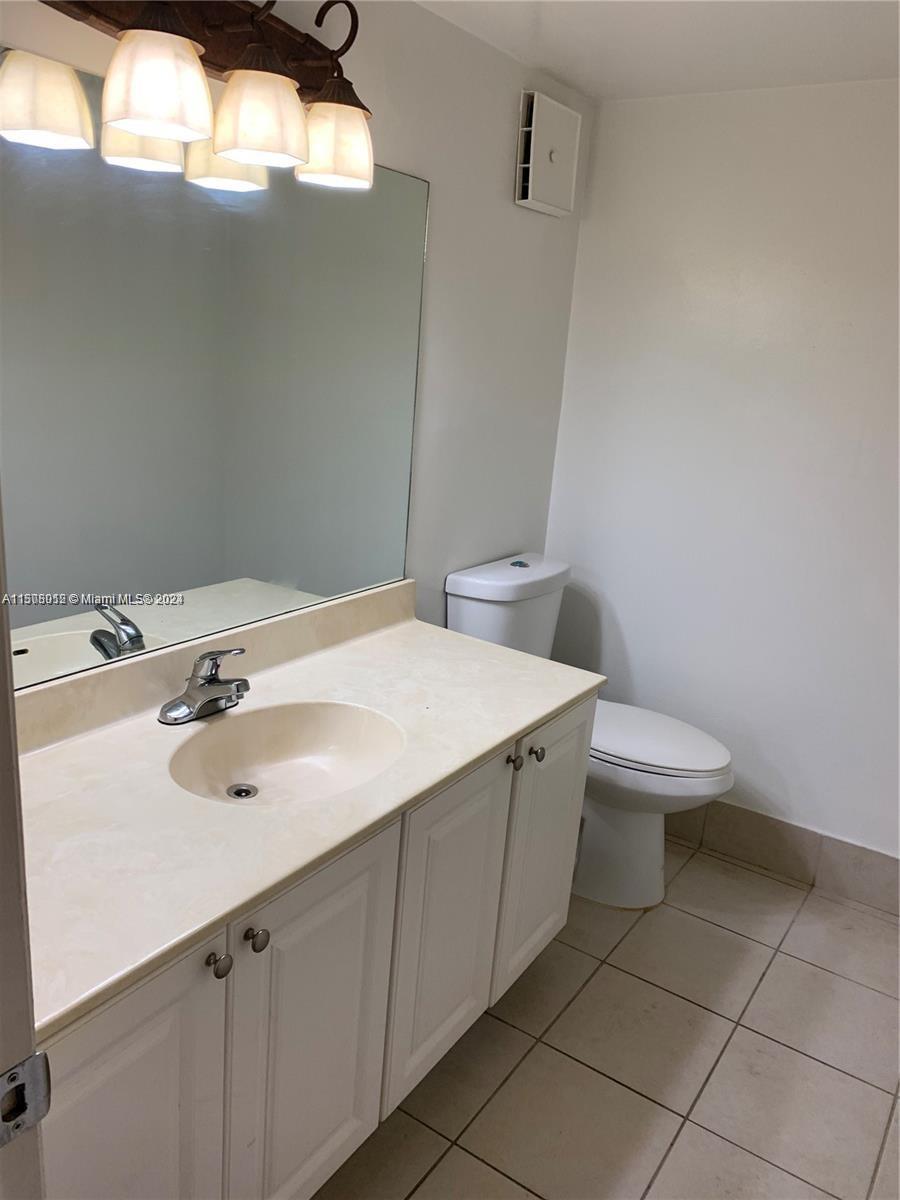 711 North Pine Island Road, Unit 111 Plantation, FL 33324 - Photo 10 of 14 a bathroom with a sink a toilet and mirror