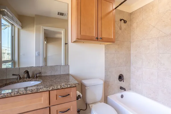 a bathroom with a granite countertop sink and a mirror