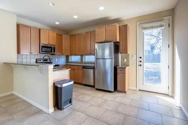 a kitchen with stainless steel appliances granite countertop a refrigerator stove a sink and a microwave