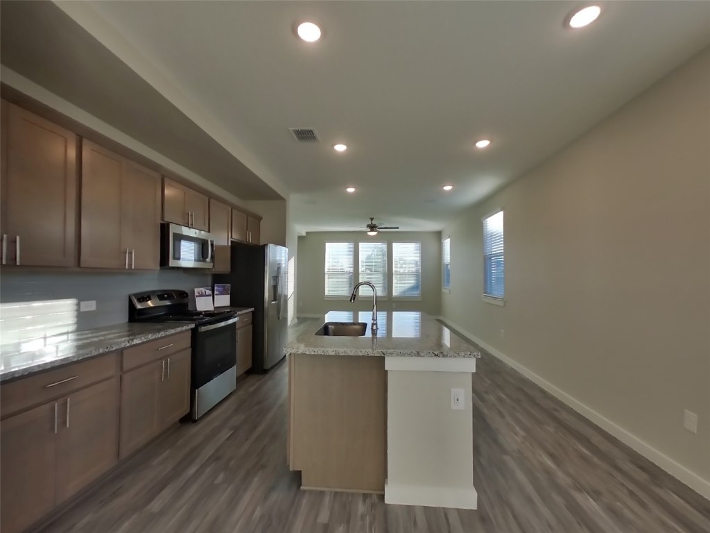 620 Raglands Road Leander, TX 78641 - Photo 4 of 30 Kitchen featuring stainless steel appliances, a kitchen island with sink, dark wood-type flooring, ceiling fan, and recessed lighting