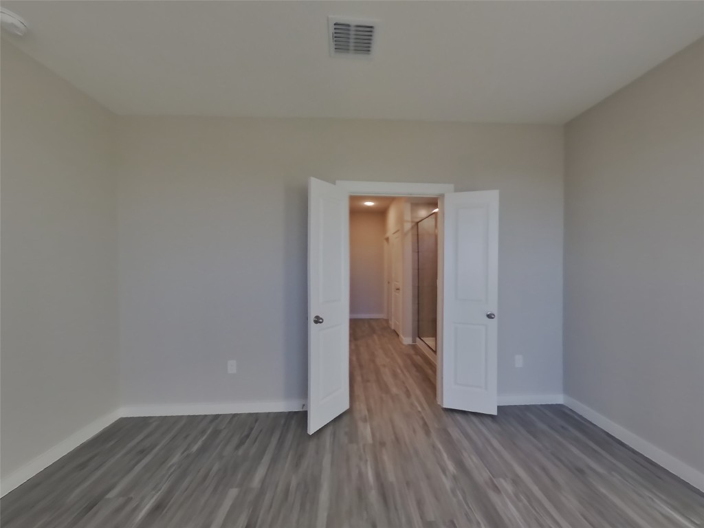 620 Raglands Road Leander, TX 78641 - Photo 5 of 30 Unfurnished bedroom with wood finished floors and baseboards